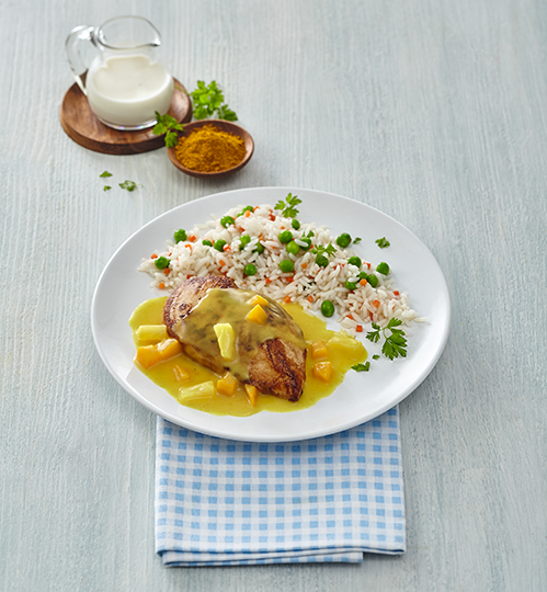 Hähnchen in gelber Currysoße, dazu Reis und Erbsen