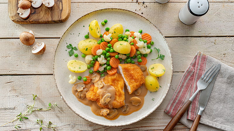 Schnitzel in Champignonsoße, dazu Kartoffeln und buntes Gemüse