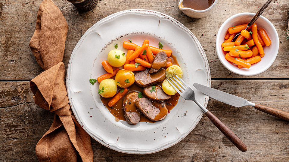 geschnittene Entenbrust in brauner Soße, dazu kleine goldgelben Kartoffeln und glasierten Möhren
