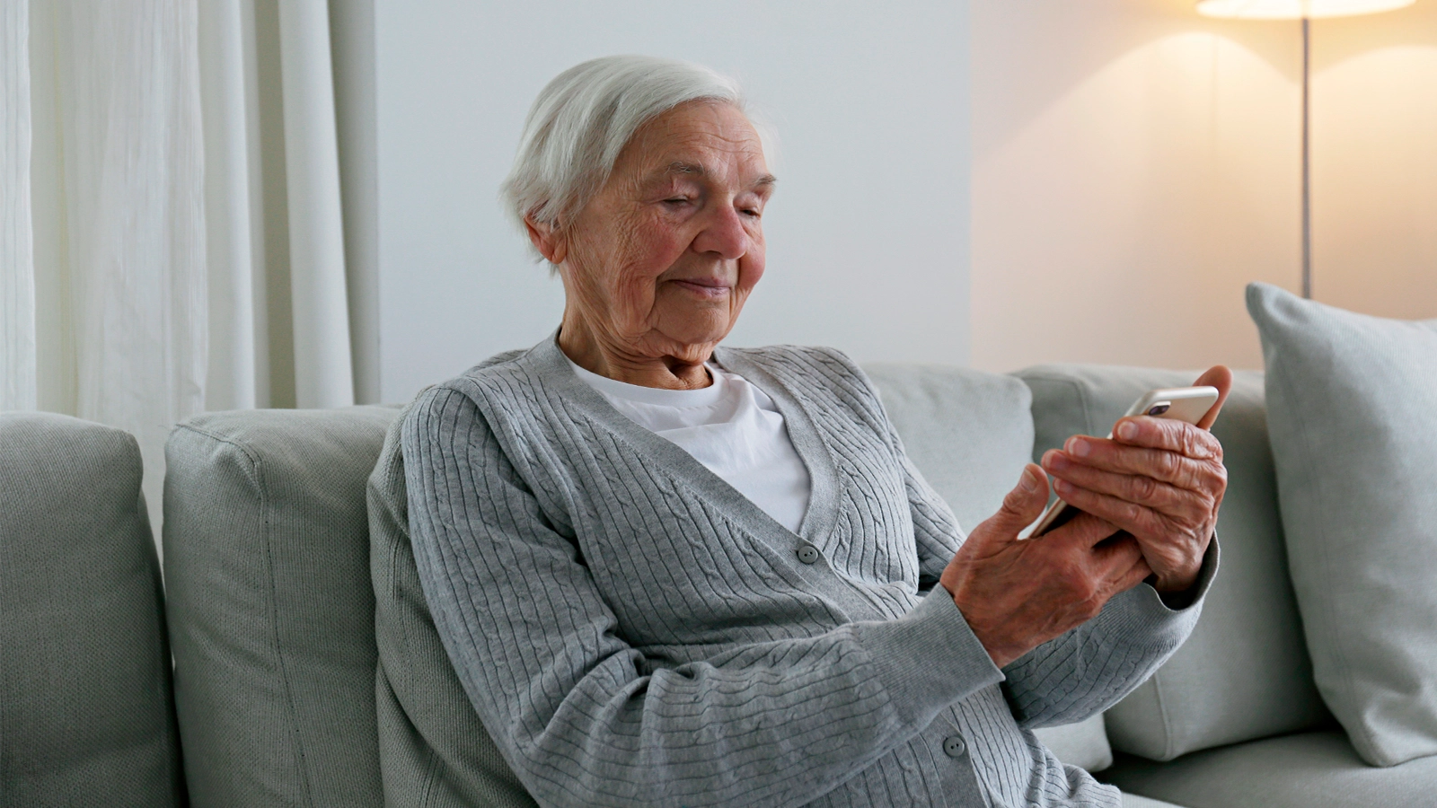 Eine Seniorin mit einem Handy in der Hand