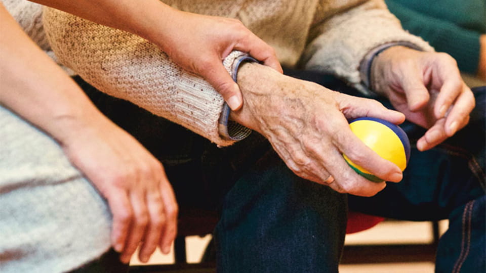 Seniorenübung mit Ball in den Händen