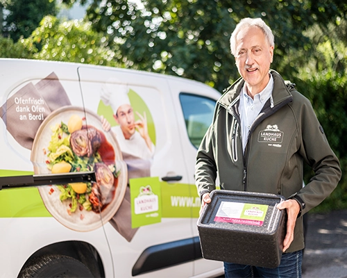 Der Menükurier Wolfgang steht vor einem Frische Mobil