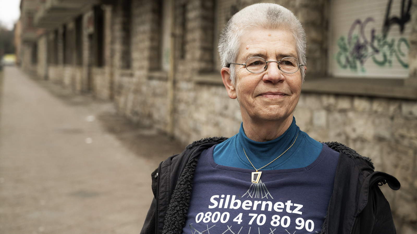 Elke Schilling, Gründerin und Vorsitzende von Silbernetz, steht vor einer Hauswand