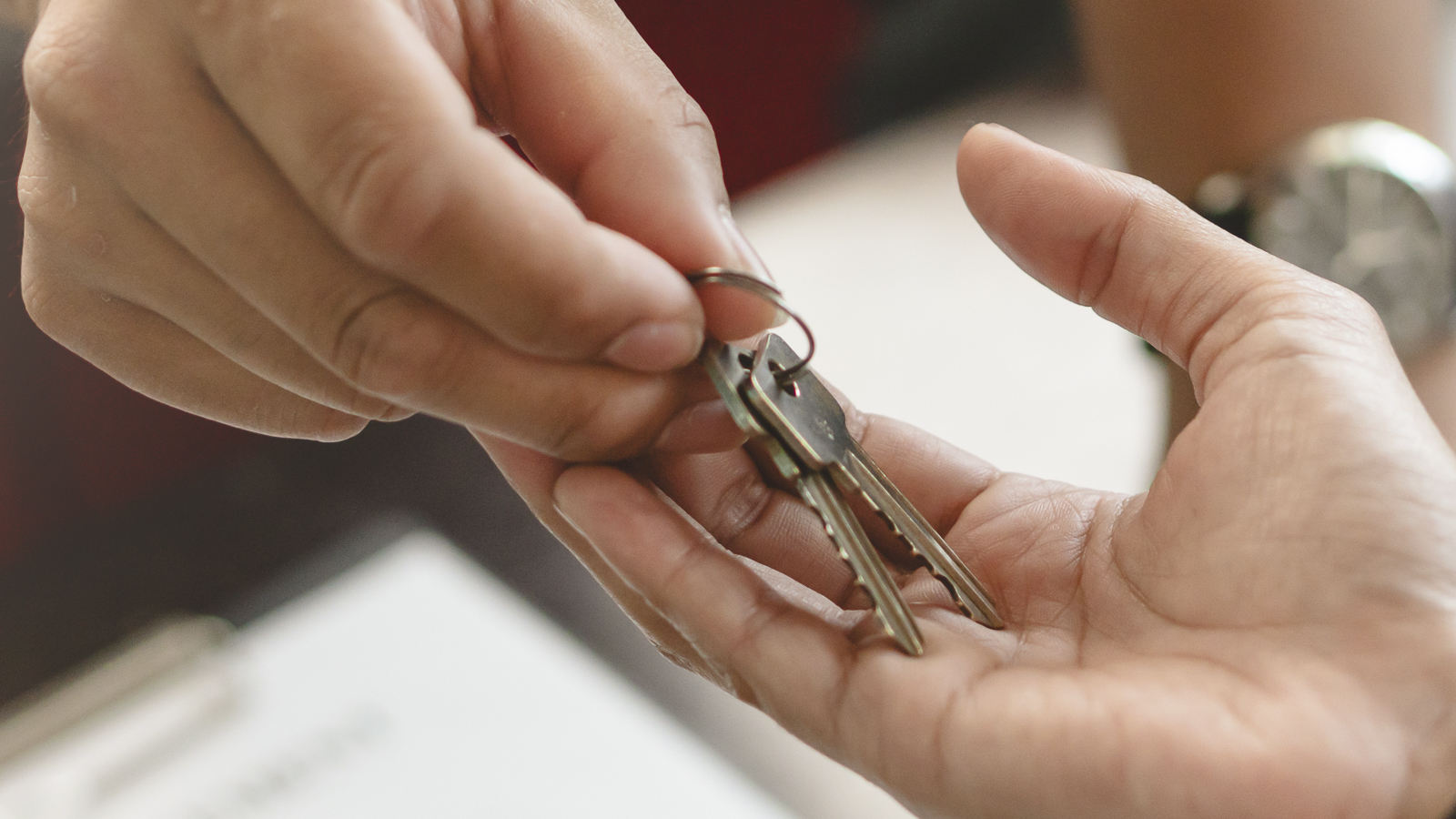 Ein Hausschlüssel wird an den Menükurier übergeben.