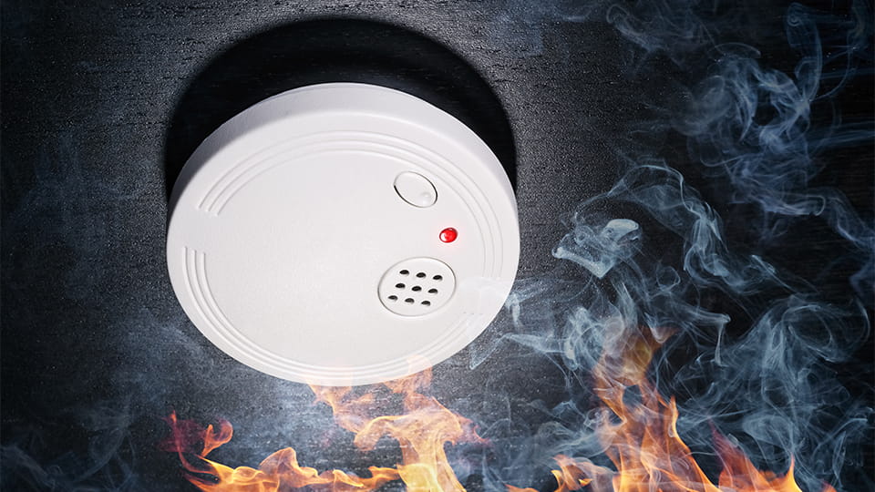 Feuermelder über Flammen und Rauch