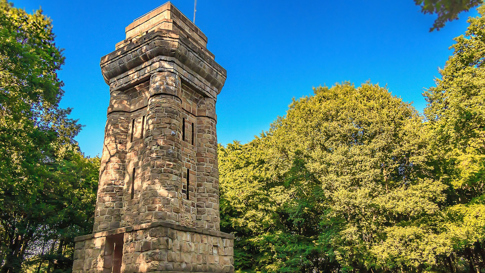 Bismarckturm Viersen umgeben von Bäumen und einem blauen Himmel