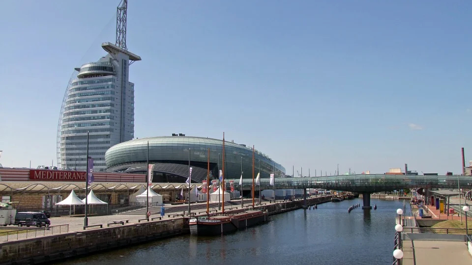 Hafenpromenade in Bremerhaven mit modernen Gebäuden sowie Segelbooten am Kai