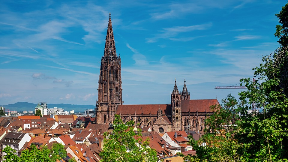 Blick auf den Freiburger Münster mit der großen Turmspitze über den Dächern der Stadt