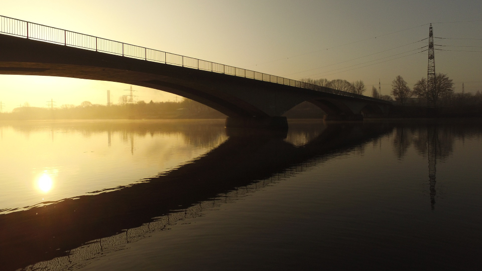 Die Brücke über dem Hengsteysee bei winterlichem Sonnenaufgang in Hagen, mit Spiegelung im Wasser