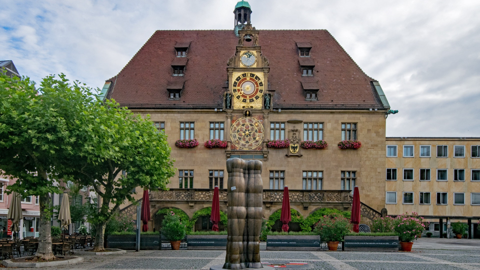 Das historische Rathaus in Heilbronn mit goldener Kunstuhr auf dem Vorplatz