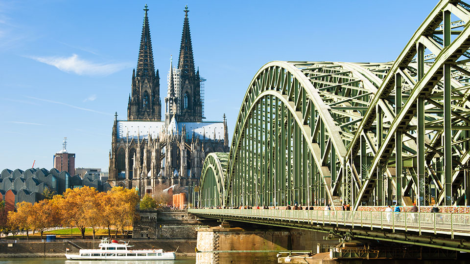 Blick auf den Kölner Dom und die Hohenzollernbrücke über dem Rhein, bei sonnigem Wetter