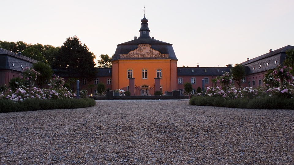 Barockes Schloss in Mönchengladbach, Kiesweg und Blumenbeeten im Vordergrund