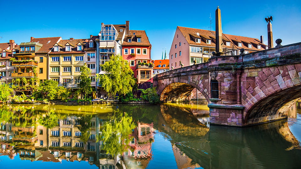 Bunte Altstadthäuser am Fluss mit Brücke in Nürnberg