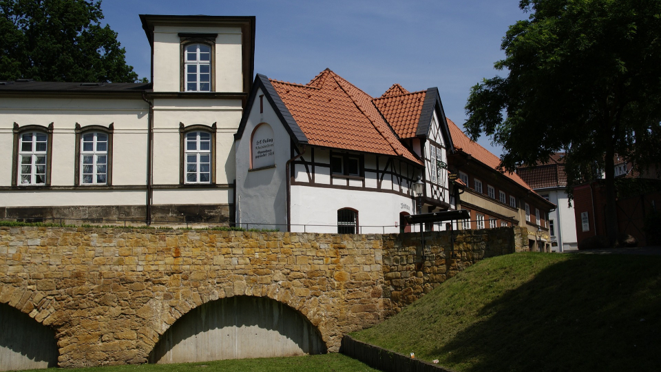 Historisches Fachwerkhaus der Burg in Peine mit roten Ziegeldächern und Steinmauer