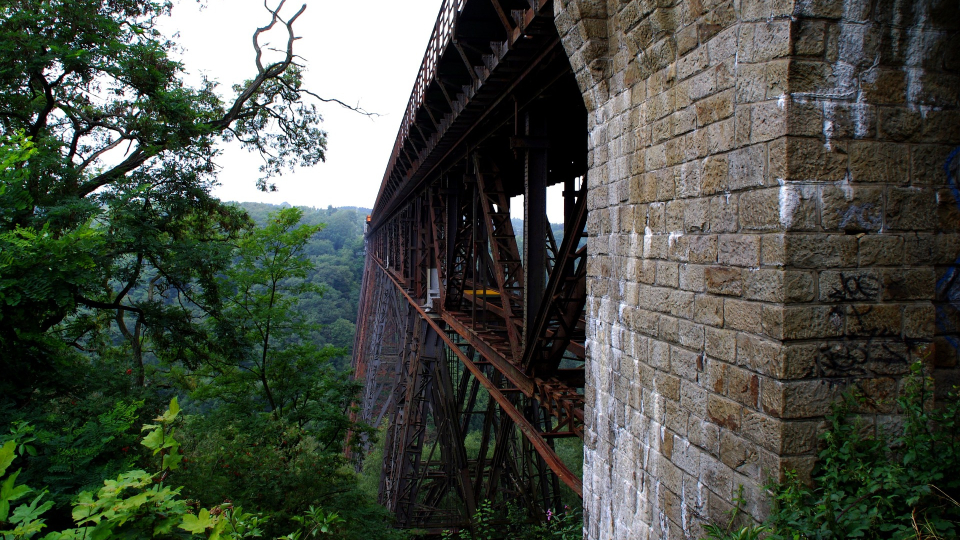 Die Müngstener Brücke Remscheid mit steinernem Pfeiler ist von Bäumen umgeben und führt über ein grünes Tal