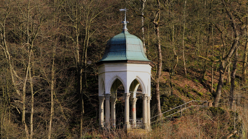 Kleiner Pavillon mit grünem Dach in einem winterlichen Wald in Solingen