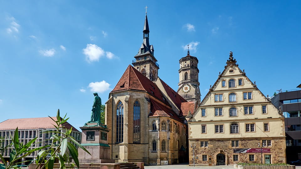 Historischer Schillerplatz in Stuttgart mit Kirche und Fachwerkhaus bei blauem Himmel