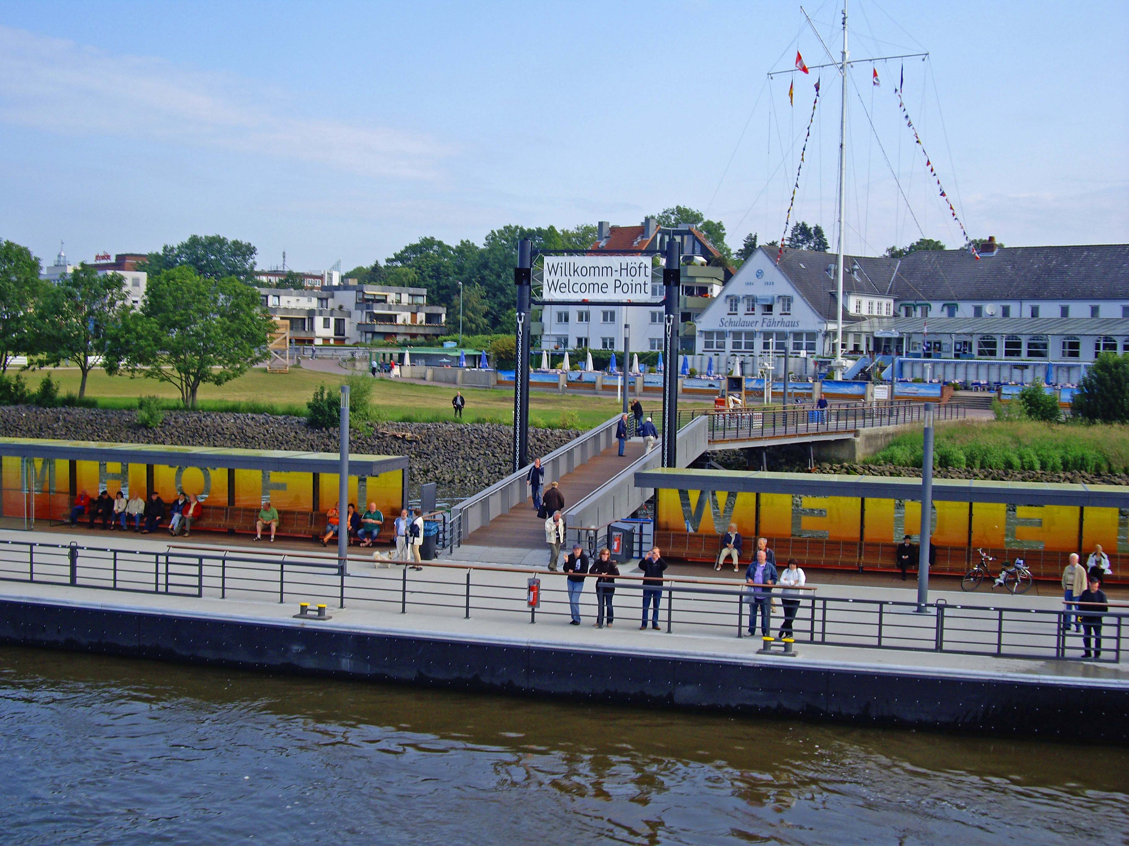 Schiffsbegrüßungsanlage ‚Willkomm-Höft‘ in Wedel am Ufer mit Sitzbänken und Flaggen 